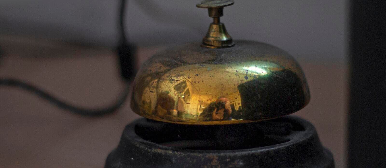 A worn brass service bell on a counter.