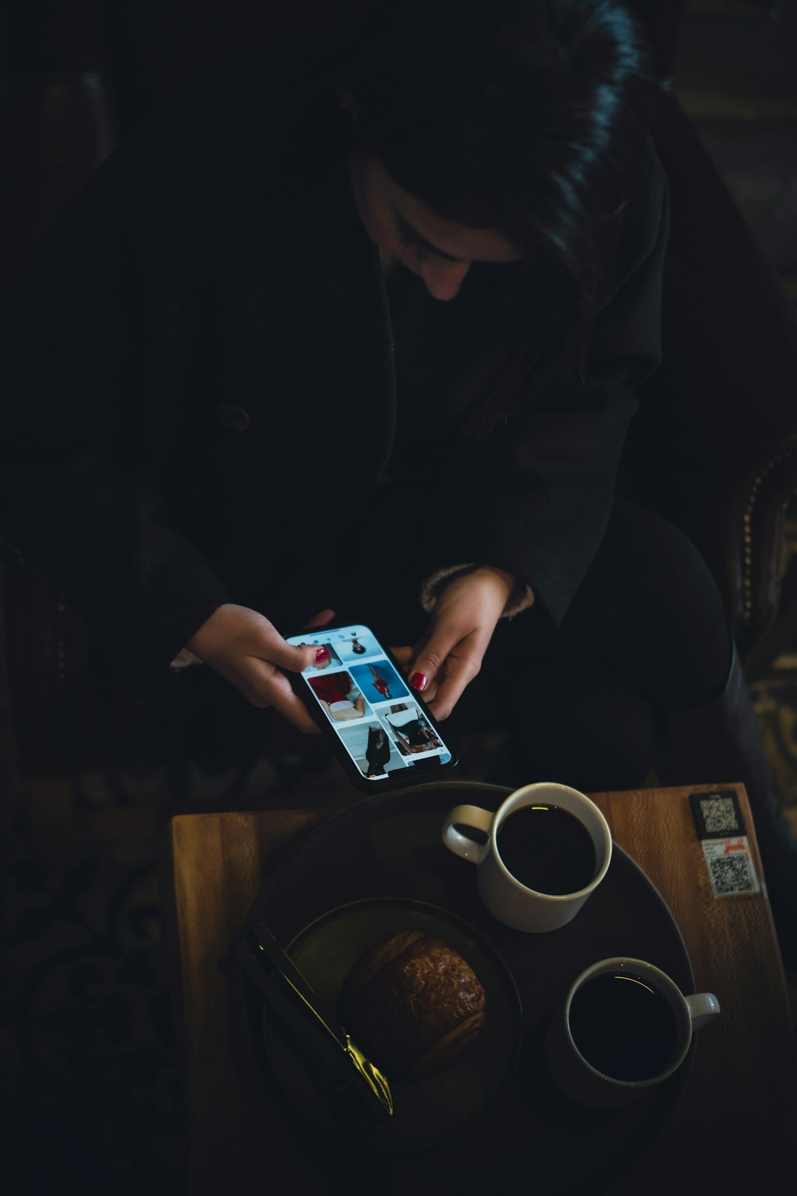 A guest reading their phone at the table, coffee going cold.