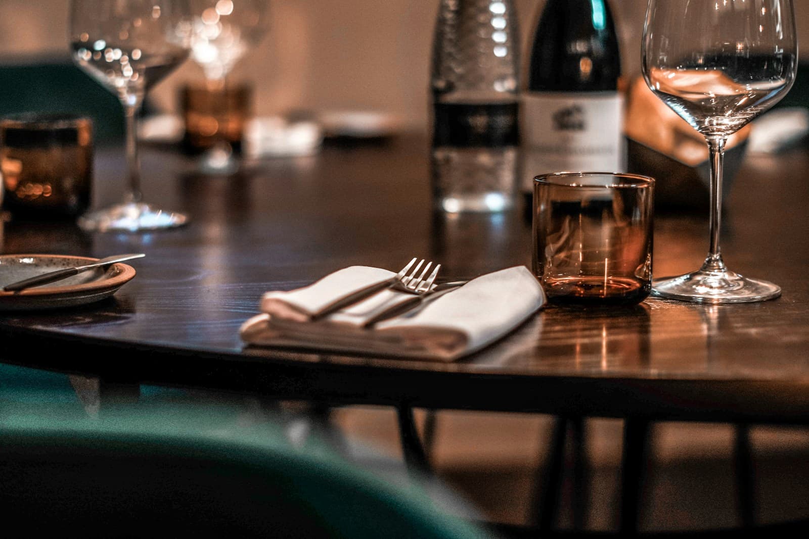 A restaurant table laid for one before service, in low evening light.