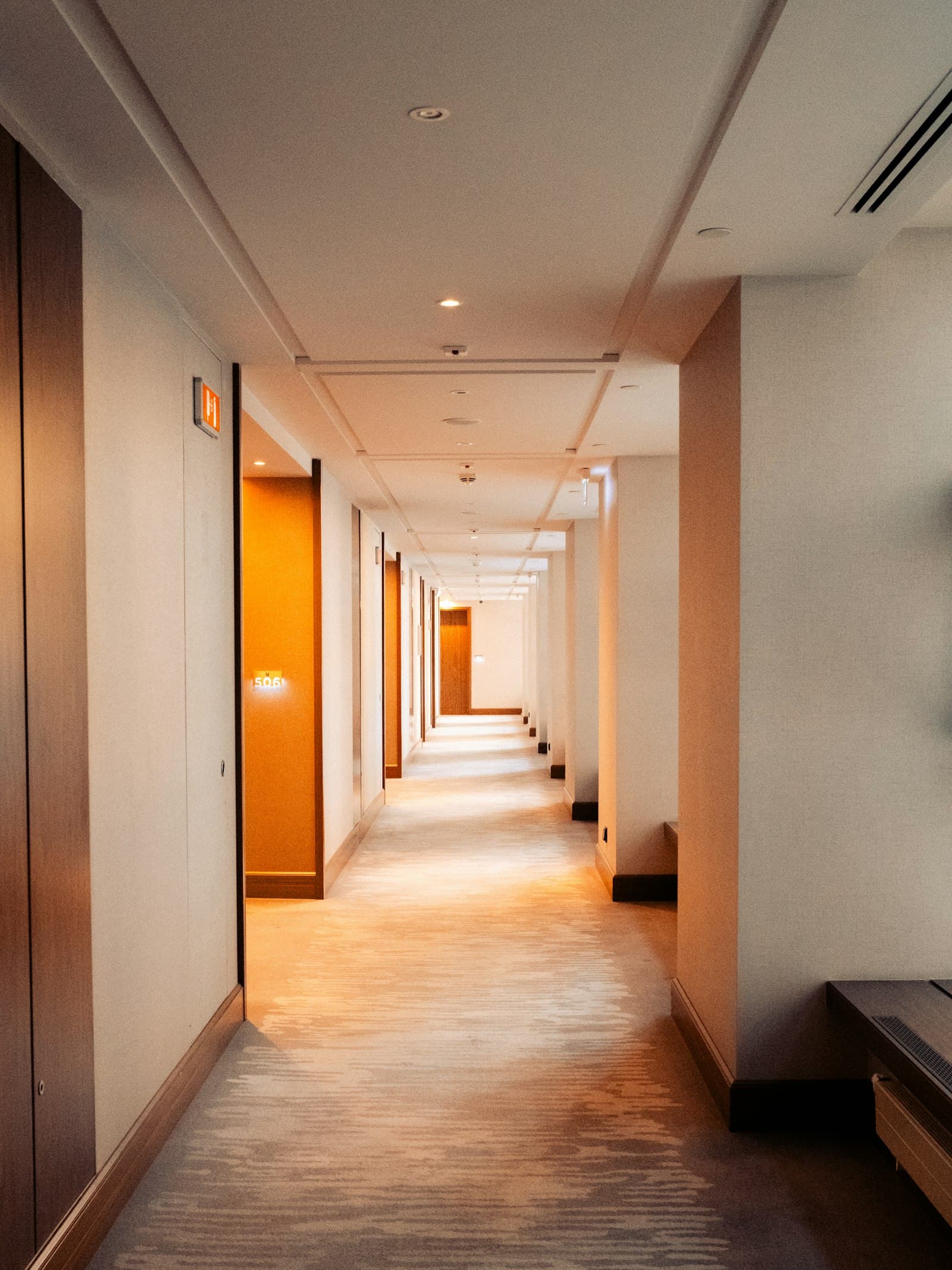 A hotel corridor at night, doors down both sides.