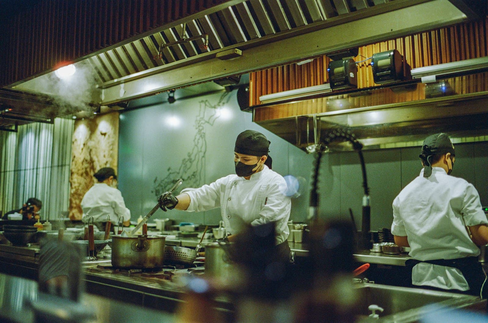 A kitchen brigade working the pass under the heat lamps.