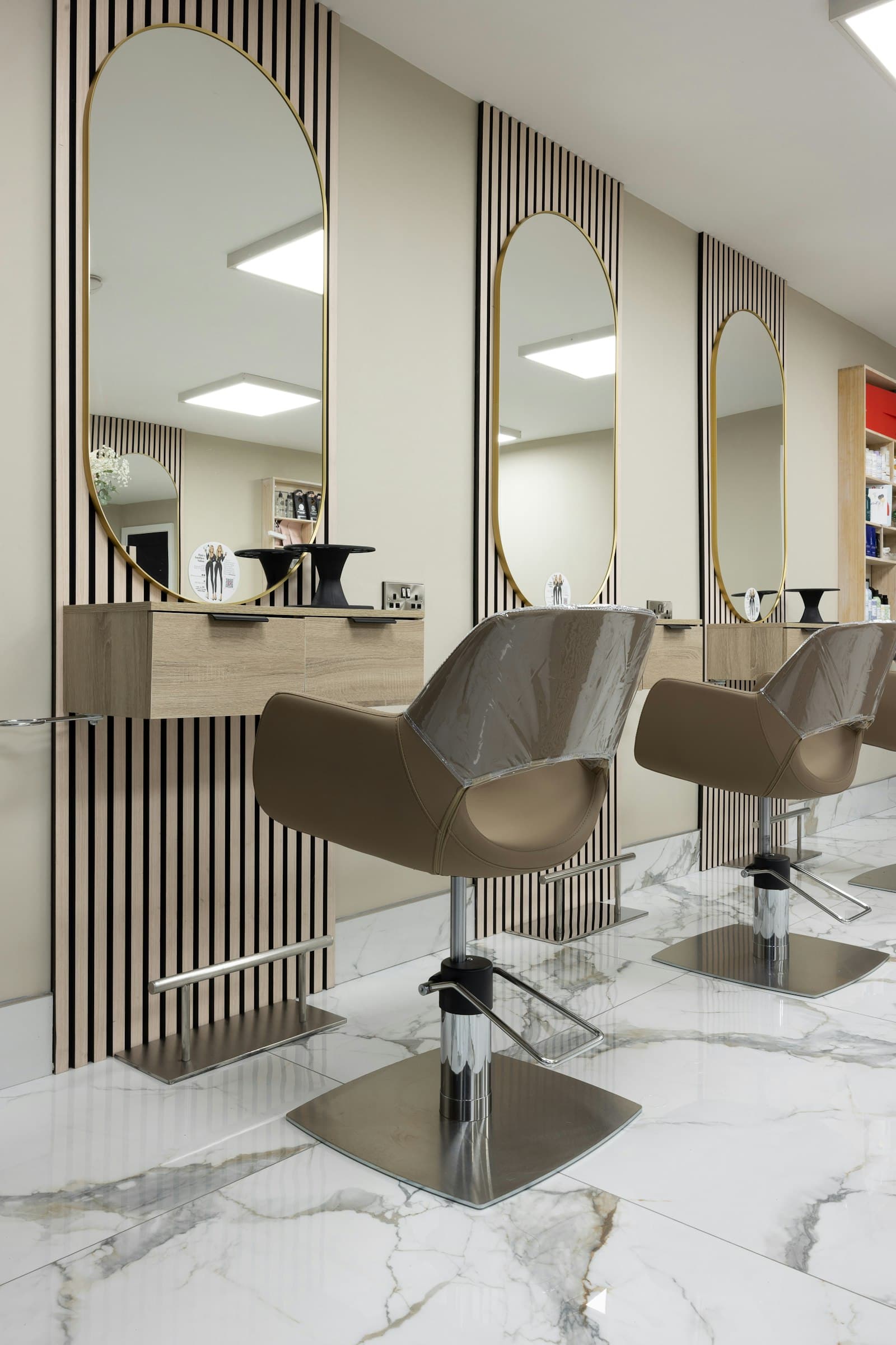 A salon floor between clients, chairs empty at the mirrors.