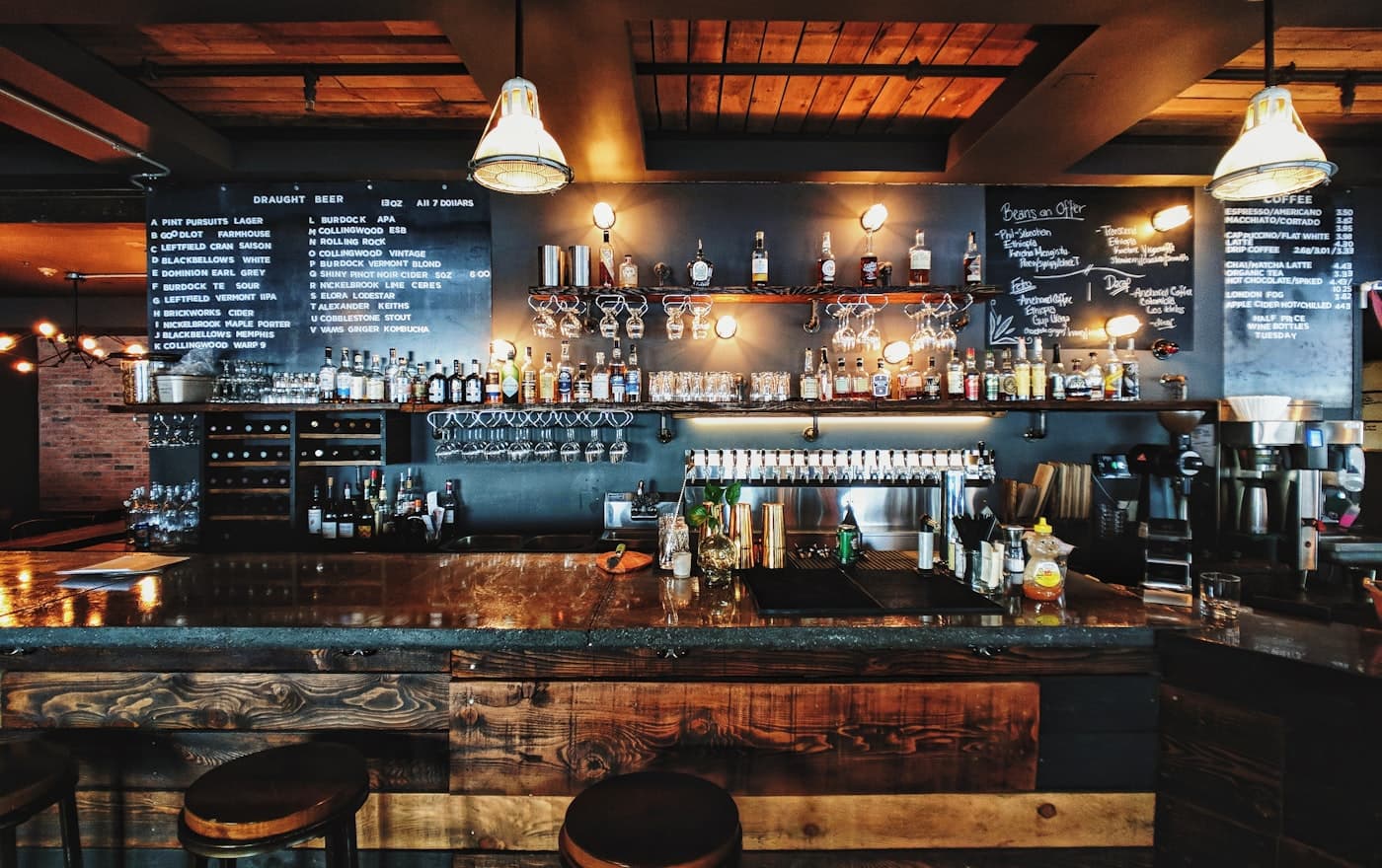 A bar after the room has gone quiet: taps, glass, nobody on the floor.