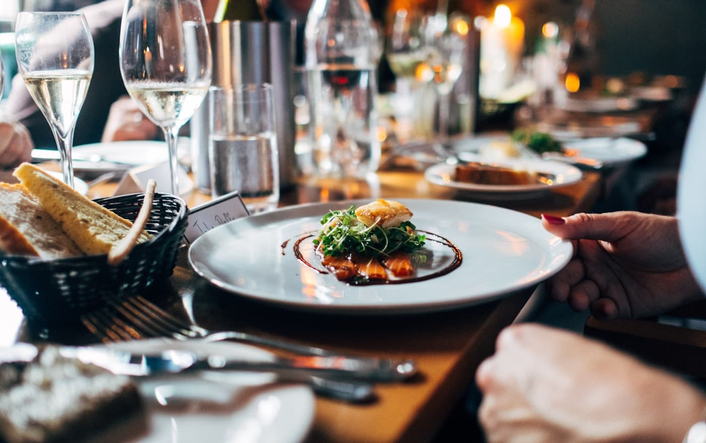 A booked dining room, tables set.