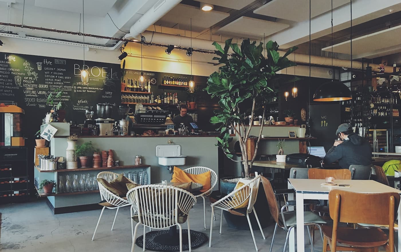A cafe floor between services, the guest already on their phone.